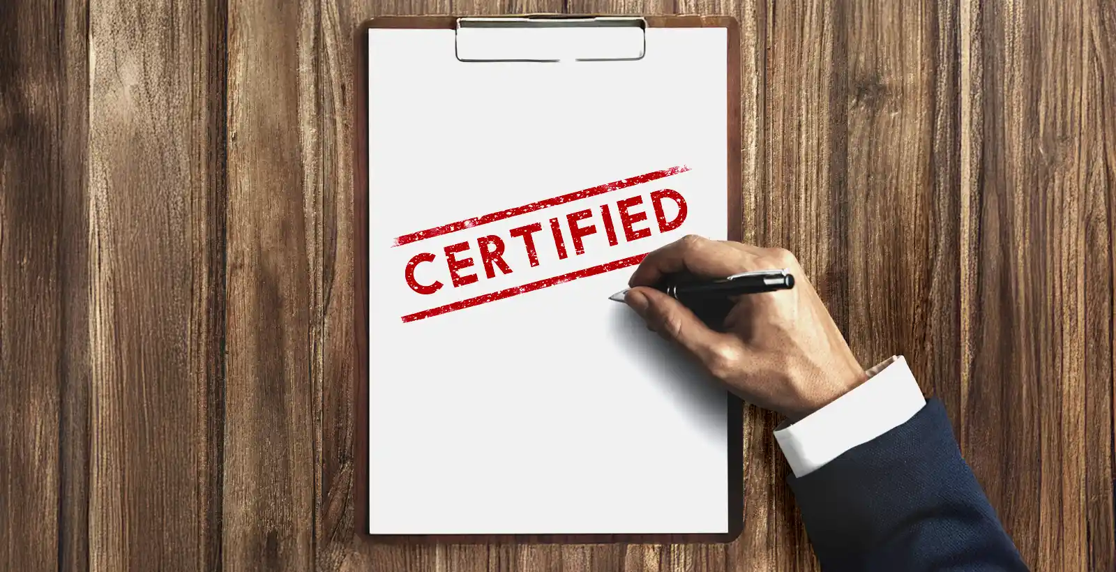 Businessman holding pen with clipboard showing the word CERTIFIED, symbolizing HITRUST certification timeline