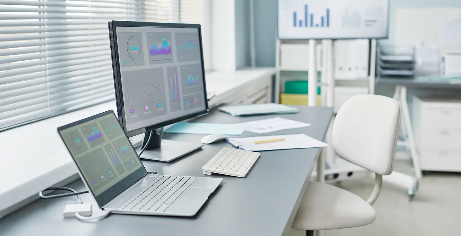 Modern office desk with data dashboards representing HITRUST readiness assessment and security compliance preparation.