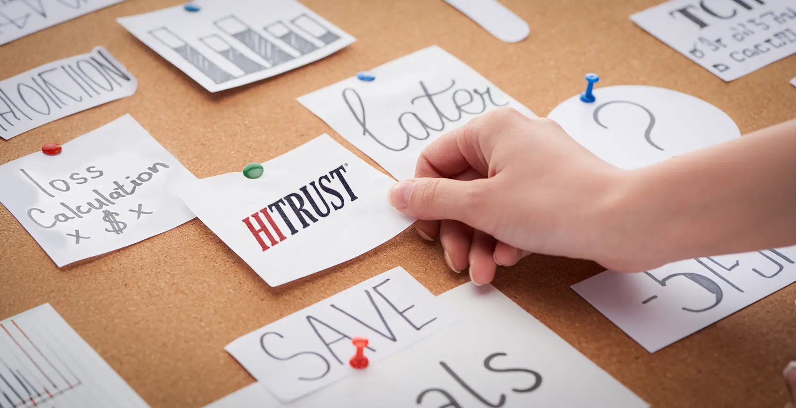 Hand pinning a HITRUST note onto a corkboard alongside cost and savings planning notes, illustrating strategic cost optimization for compliance certification.