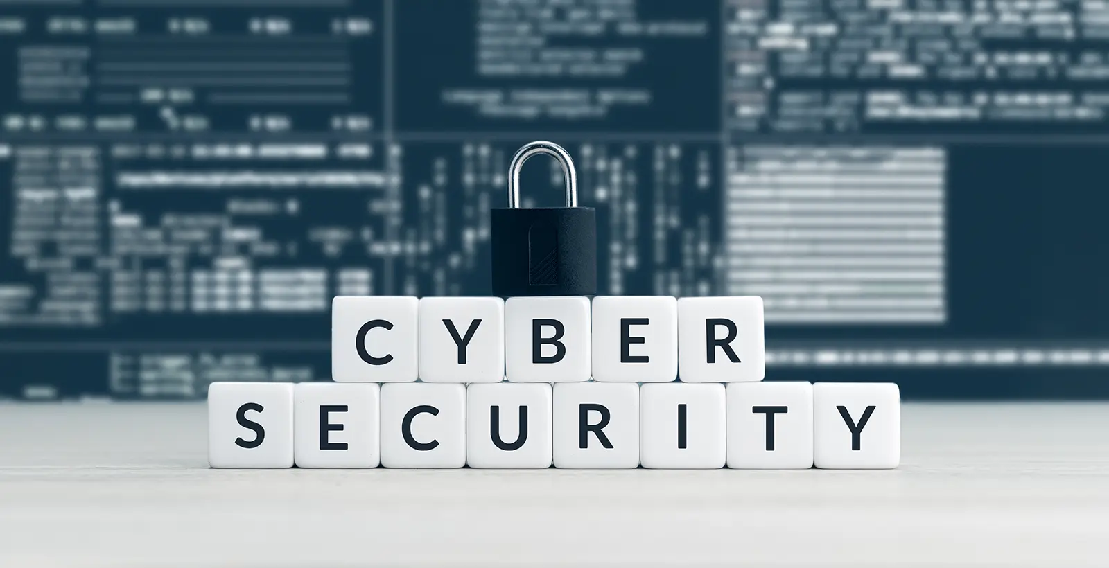A black padlock resting on white blocks spelling "CYBER SECURITY" against a blurred digital background, representing a vCISO's role in building business resilience.
