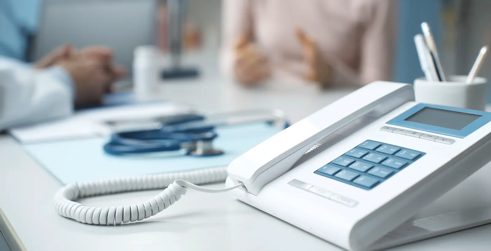 Telephone on a doctor’s desk, illustrating healthcare contact center and customer experience services.